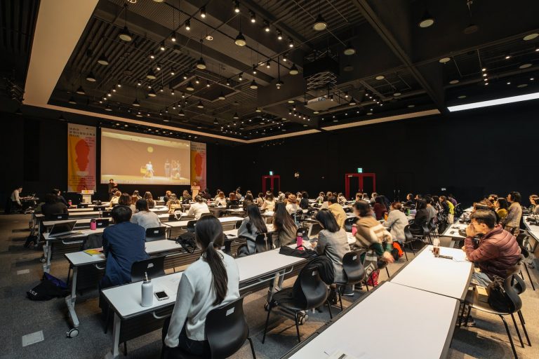 audience sitting at their desks at a conference.