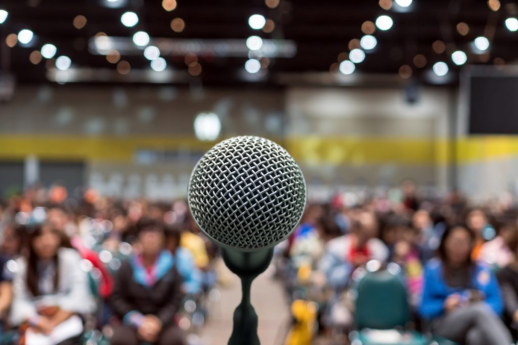 A microphone in front of a blurred-out crowd