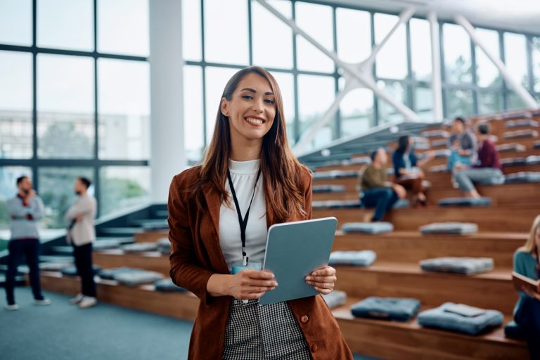 An event manager posing with a tablet in her hand at an event center.