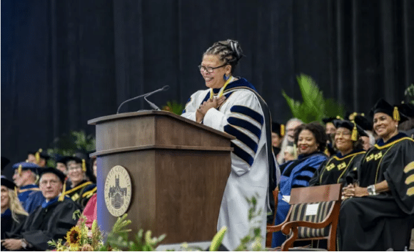 person giving speech behind wood podium