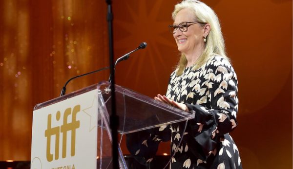 Meryl Streep standing smiling at an acrylic lectern