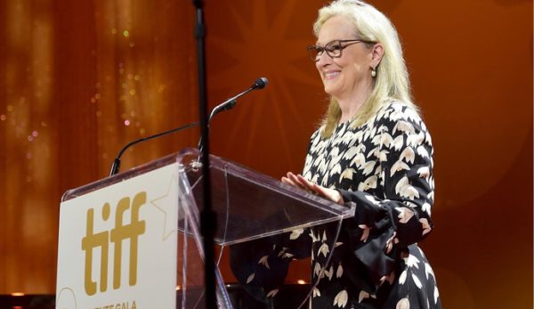 Asset-38@3xs-100.jpg Meryl Streep standing smiling at an acrylic lectern