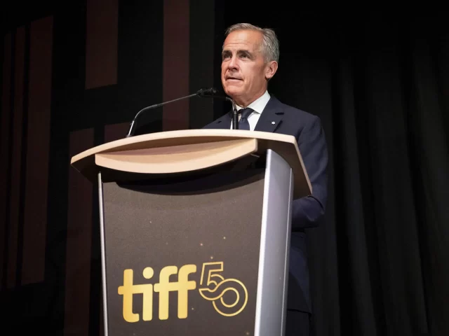 Prime Minister Mark Carney speaking behind the VH1 Custom Maple Podium at the “John Candy: I Like Me” TIFF premiere 🎬🍿🎞️
